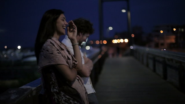 Couple at night romantic moment talking on bridge