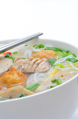 Bun cha ca or Vietnamese rice vermicelli with grilled fish and herbs on a white background