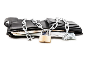 Chain padlock on leather wallet full of dollar currency money