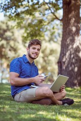 hipster using laptop and phone in the park