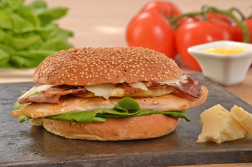 Hamburguesa de pollo e ingredientes sobre plancha caliente.