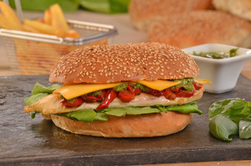 Hamburguesa de pollo e ingredientes sobre plancha caliente.