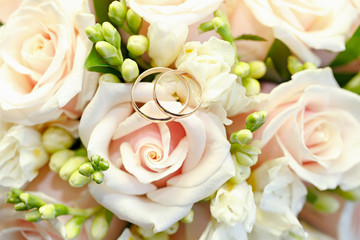 Gold wedding rings on a bouquet of flowers for the bride