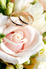 Gold wedding rings on a bouquet of flowers for the bride
