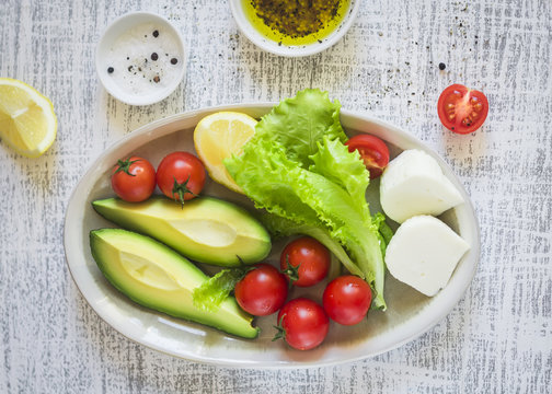 ingredients for salad with avocado, cherry tomatoes and cheese 