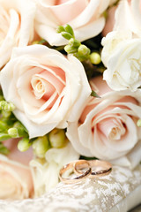 Gold wedding rings on a bouquet of flowers for the bride