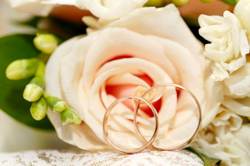 Gold wedding rings on a bouquet of flowers for the bride