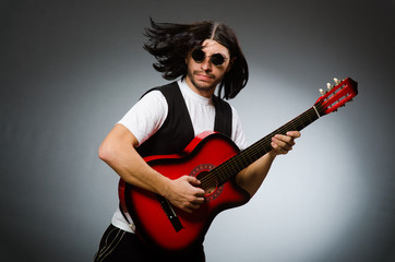 Man wearing sunglasses and playing guitar