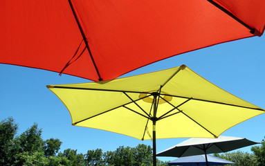 Large sun umbrellas shade patio picnic tables.