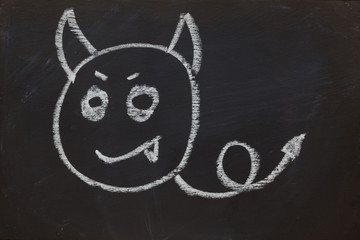 smile devil face on black chalk board
