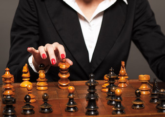 Businesswoman making his checkmate move.