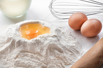 white background with egg in flour