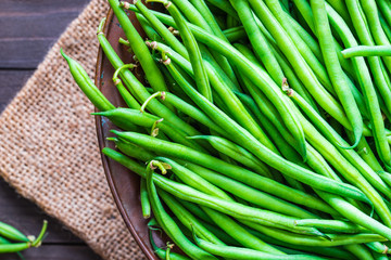 Green beans or string beans on rustic wood. - obrazy, fototapety, plakaty