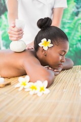 Obraz na płótnie Canvas Pretty woman enjoying a herbal compress massage