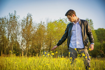 Handsome young man at countryside, in field or grassland