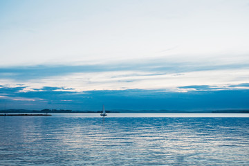 Obraz premium Yacht sailing against sunset