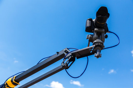 Camera on a crane on a blue sky background