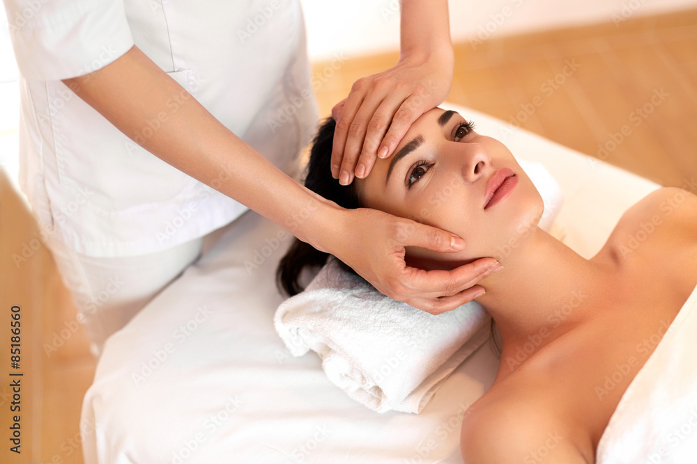 Wall mural face massage. close-up of a young woman getting spa treatment.