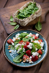 Salad with spinach, strawberry and cheese, rustic wooden surface