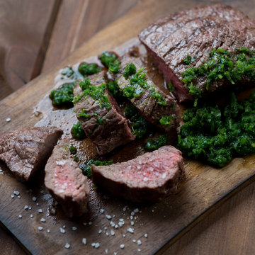 Medium rare grilled beef steak with chimichurri, selective focus