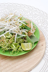 Vietnamese herbs on a cutting board with tablecloth