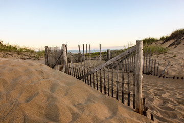 Fence with sand dunes and sky