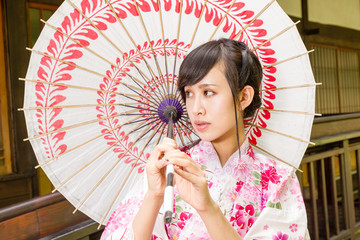 Asian woman in kimono holding umbrella