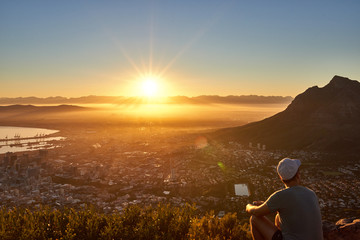 Young guy watching the sunrise over the city