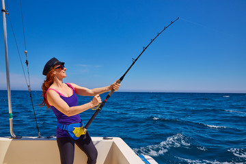 Beautiful woman girl fishing rod trolling in boat