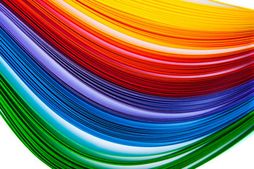 Rainbow colored quilling paper laid out in waves and shapes