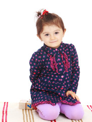 Little girl sitting on the rug in Montessori kindergarten