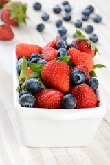 White Bowl of Strawberries and Blueberries on Rustic Table