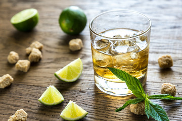 Glass of rum on the wooden background