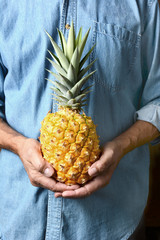 Man Holding Ripe Pineapple