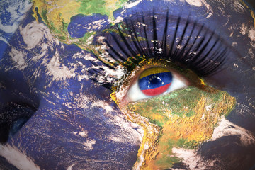  woman's  face with planet Earth texture and venezuelan flag inside the eye.