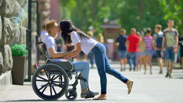 7 in 1 video! The woman carry disabled man in the wheelchair in the crowd stream at sidewalk. Social video. Shot with Red Cinema Camera