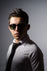 Obraz premium Young man in cool sunglasses isolated on gray
