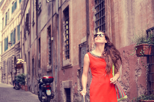beautiful woman in red summer dress walking smiling in Rome, Italy