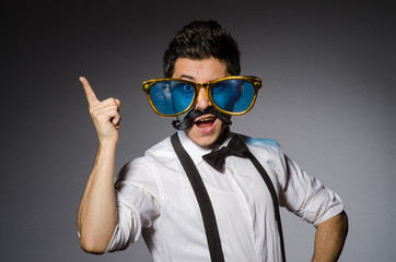 Young man with false moustache and large sunglasses isolated on