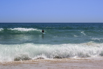 Ocean view and people surfing in Tavira Island beach, Algarve