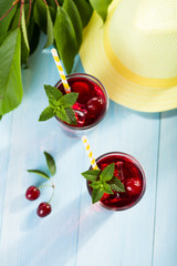 Glass of cherry juice on blue wooden table