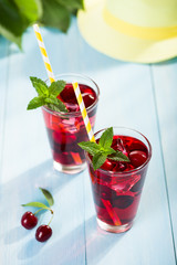 Glass of cherry juice on blue wooden table