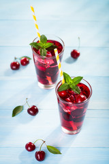Glass of cherry juice on blue wooden table