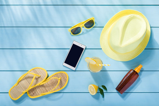 Summer accessories on blue wooden background top view