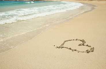 heart drawn in the sand on the beach