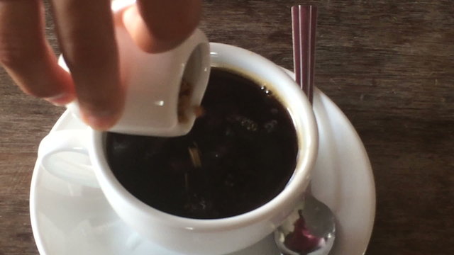 Adding sugar in coffee cup and stirring, stock video