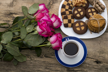 pink roses, coffee and cookies top view