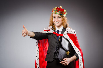 Pretty businessman with crown and case isolated on gray