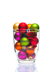Multi-colored Christmas balls in a vine glass isolated on white.