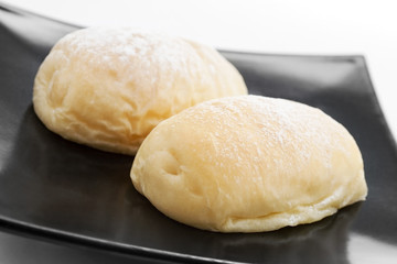 Fresh butter bread on black plate